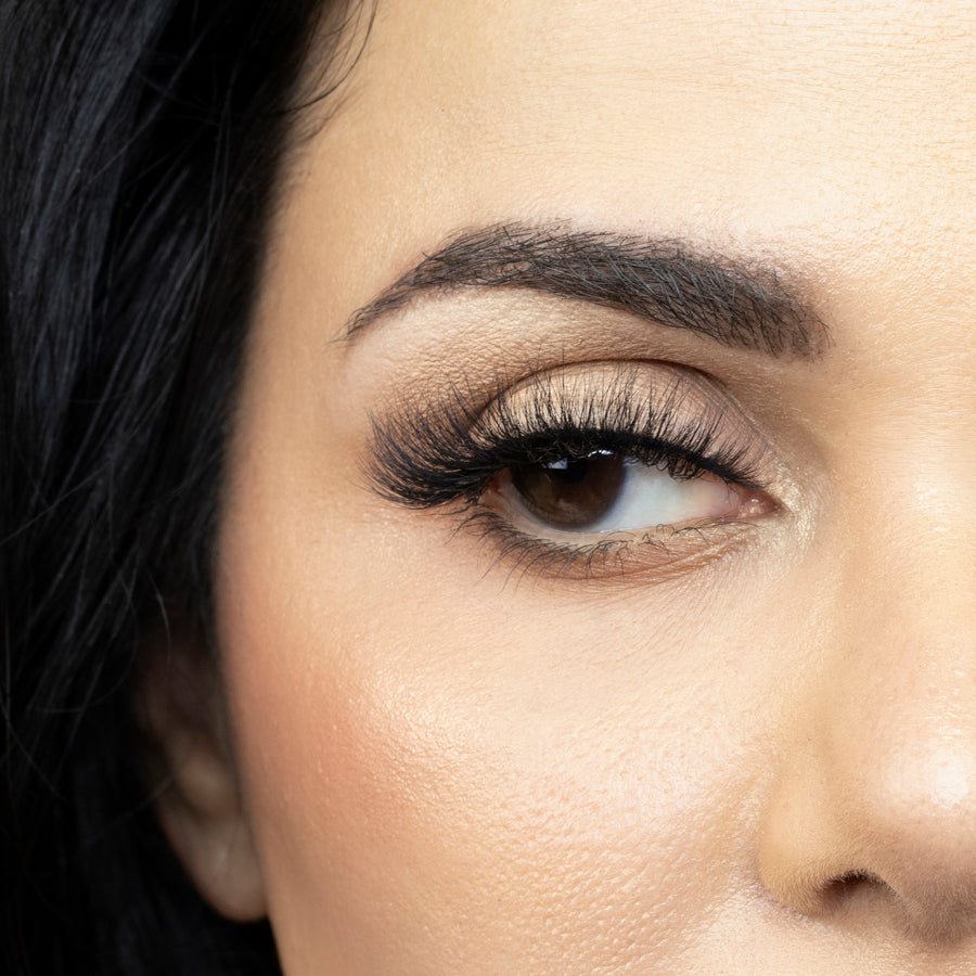 Suntarah Beauty 3D Faux Mink False Strip Eyelash in Style F-105. Close up of young woman wearing lash looking to the side. Lash has a wispy and foxy look.