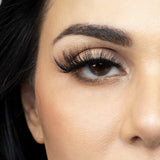 Suntarah Beauty 3D Faux Mink False Strip Eyelash in Style F-106. Close up of young woman wearing lash looking straight ahead.