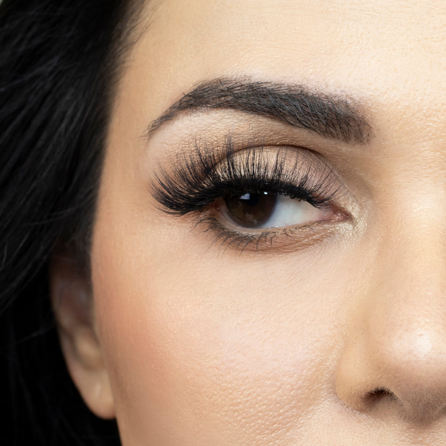 Close up of woman’s right eye while wearing Suntarah Beauty 3D Faux Mink False Strip Eyelash in F-107.  Woman is looking to the side.