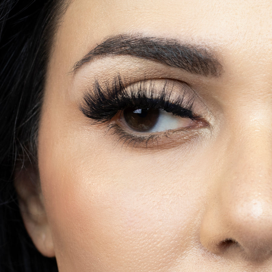 Suntarah Beauty 3D Faux Mink False Strip Eyelash in Style F-109. Close up picture of young woman wearing lash looking to the side.