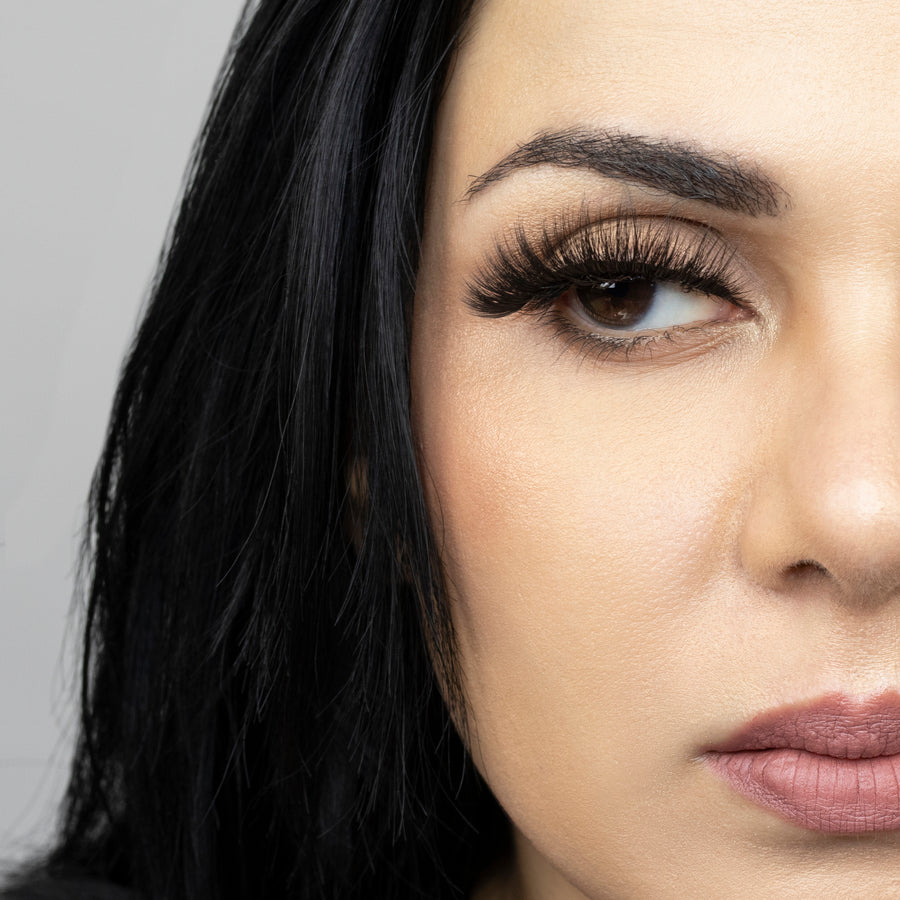 Close up of woman’s right eye while wearing Suntarah Beauty 3D Premium Synthetic false strip eyelash in style S-225.  Woman is looking to the side.  